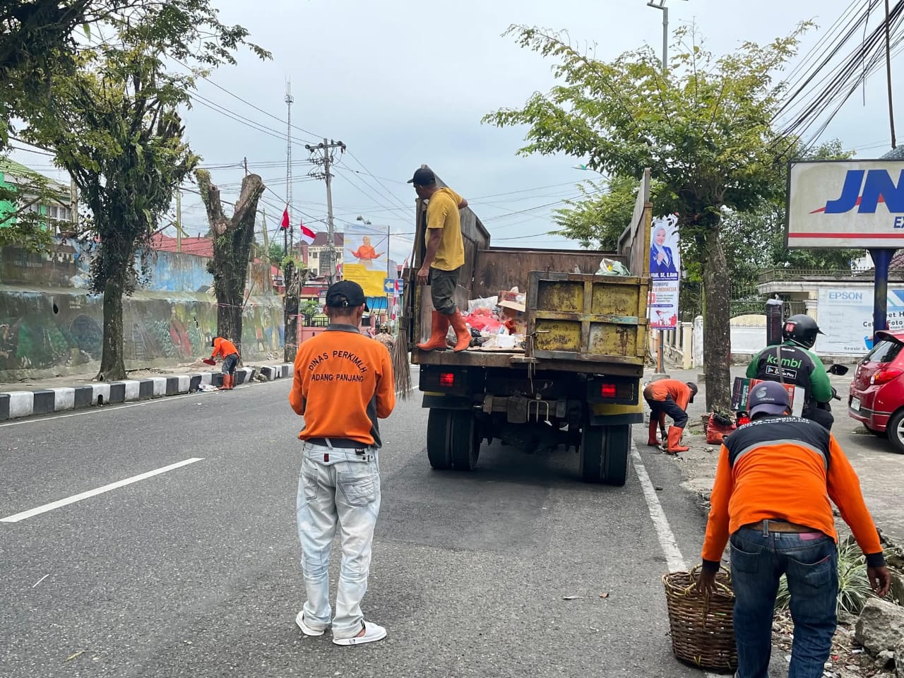 Petugas dari Dinas Perkim LH saat bersihkan sampah dijalanan usai pawai alegoris.